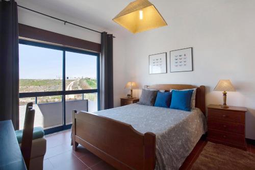 阿托吉亚达巴莱亚Sao Bernardino Beach House的一间卧室设有一张床和一个大窗户