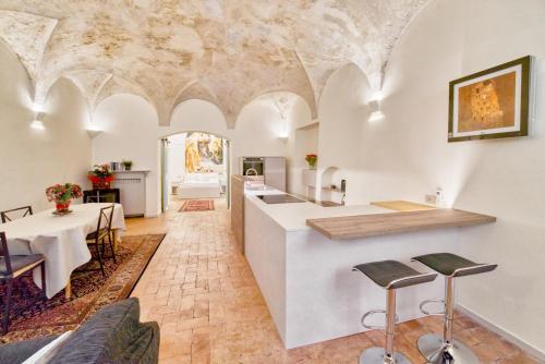 帕尔马Il Loft di Quintino的厨房以及带桌椅的起居室。