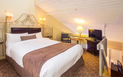 魁北克市奥伯格魁北克酒店的一间酒店客房,配有一张大床和一台平面电视