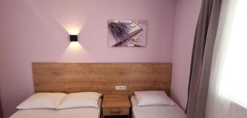 阿维萨阿达西Motel Lavanda的墙上有灯的房间里设有两张床
