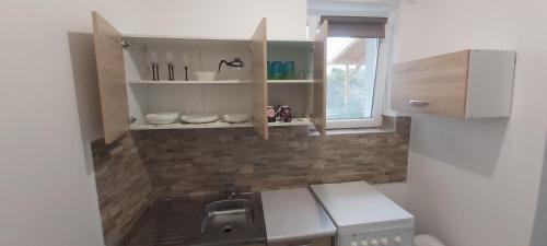 鲍洛托努德沃里Lali Apartman的一个带水槽和窗户的小厨房