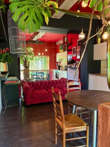 PoelkapellePlantkot -Boekenkot -Kunstkot en love kot的一间设有红色沙发和一张桌子的用餐室