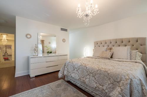 迈阿密Luxurious and cozy Townhouse 3 bedrooms 2.5 Bath的一间卧室配有一张大床和一个吊灯。