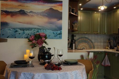 布勒伊-切尔维尼亚Window on the mountains的厨房里摆放着酒杯和鲜花的桌子
