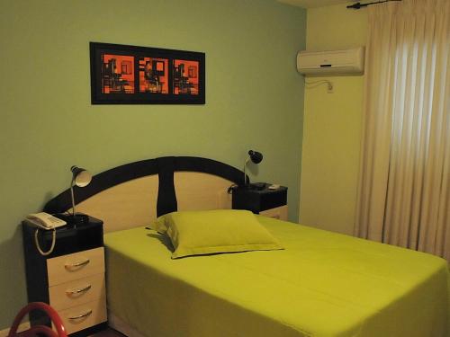 里韦拉乌拉圭布瑞斯丽酒店的一间卧室配有一张黄色床罩的床