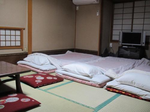 东京富士旅馆的一张大床,地板上配有白色毯子和枕头