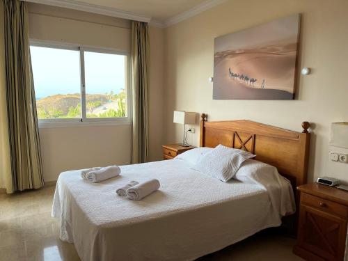 福恩吉罗拉Fantástico Apartamento con vistas al mar zona Club la Costa Castillo Fuengirola的一间卧室配有一张床,上面有两条毛巾