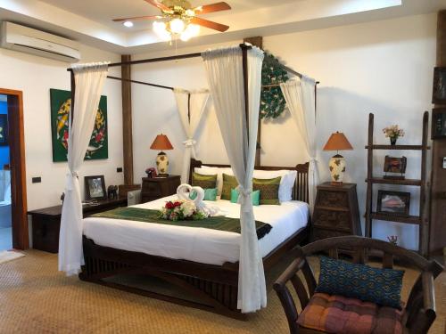 琅勃拉邦On The Mekong Resort的一间卧室配有带鲜花的天蓬床