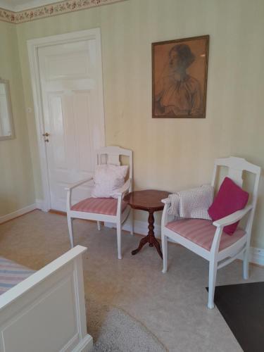 UrshultKurrebo的一间设有两把椅子和一张桌子的房间,还有一幅画