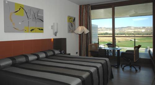 阿尔卡拉德荷那利斯塞尔科泰尔艾西恩高尔夫酒店的一间卧室配有一张床、一张书桌和一个窗户。