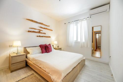 卡拉隆加Can Balafi的白色卧室配有床和镜子