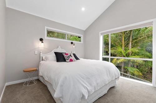 凯里凯里Seaside Serenity - Kerikeri Holiday Home的白色的卧室设有床和大窗户