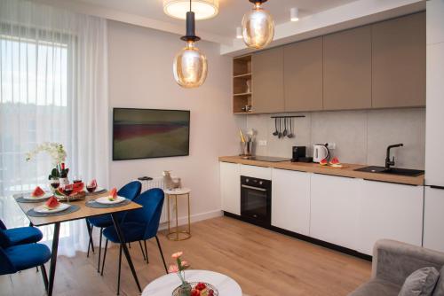 格但斯克Maya's Flats & Resorts 30 - 3 rooms flat in Garden Gate Gdansk的厨房以及带桌椅的起居室。