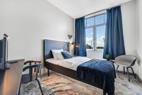 霍尔滕Thon Partner Hotel Horten的一间卧室配有一张床、一张书桌和一个窗户。