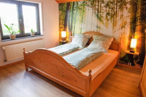 黑伦塔尔Eifelruh的一间卧室配有一张木床,墙上挂有绘画作品