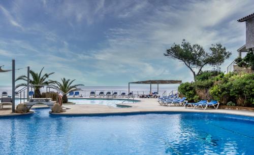桑特费柳德吉克索尔斯Eden Roc Hotel & Spa by Brava Hoteles的一个带桌椅的度假村游泳池