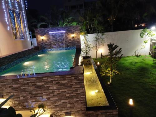 钦奈Mer Vue Villa, Kovalam, ECR, Chennai的后院,晚上设有游泳池