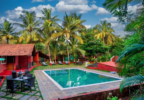 达博利Lotus an Eco Beach Resort Dapoli Murud的一个带游泳池和棕榈树的度假村