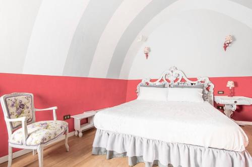 马丁纳弗兰卡La chiocciola grigia的红色和白色的卧室配有床和椅子