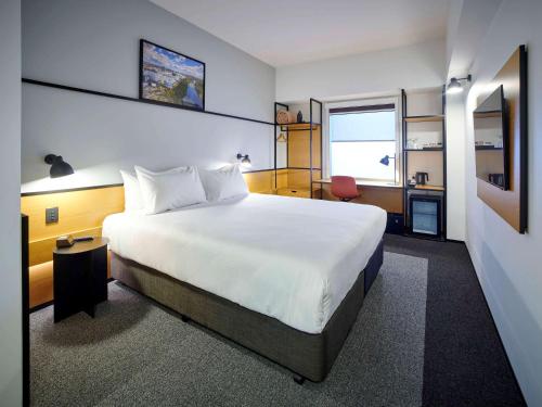汉密尔顿汉密尔顿泰努伊宜必思酒店的卧室配有一张白色大床和一张书桌