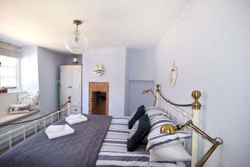 莱姆里吉斯17 Mill Green的一间卧室配有一张带枕头的床和壁炉