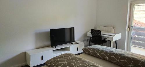 申贝格Ferienwohnung zur Kirschblüte的客厅配有平面电视和书桌。