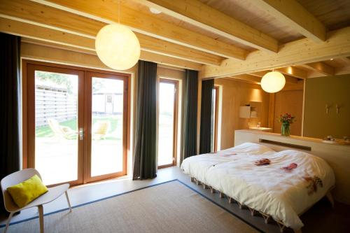 登堡Bed & Coffee Skilleplaatsje的一间卧室设有一张床和一个大窗户