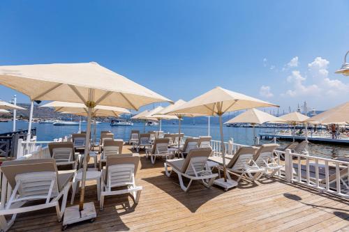 塞利米耶鲁那贝孔威塔司酒店的水面上带椅子和遮阳伞的甲板