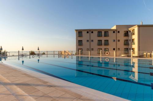 卡拉古诺内Hotel Brancamaria的一座大型游泳池,其建筑背景为:
