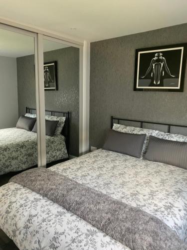 坎伯利Shore Times Holiday Chalet Parkdean K75的一间卧室设有两张床和大镜子