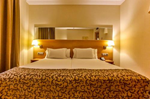 圣佩德罗-德里瓦斯德希特斯酒店的一间卧室配有一张大床和两个枕头