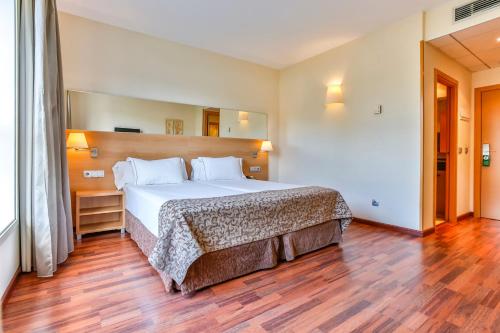 圣佩德罗-德里瓦斯德希特斯酒店的一间卧室设有一张大床,铺有木地板
