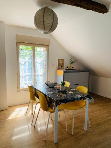 拉弗雷切Centre ville (2): superbe appartement climatisé的一间带桌子和黄色椅子的用餐室