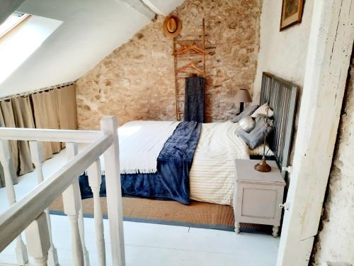 诺让莱罗特鲁Charmante maisonnette en duplex au pied du Château的卧室配有一张石墙床