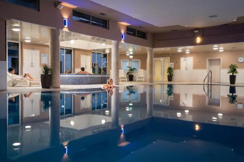 纽卡斯尔Burrendale Hotel Country Club & Spa的一座有背景人员的建筑中的游泳池