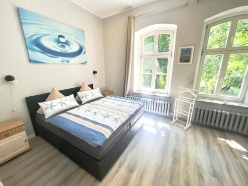施特拉尔松德Gästehaus Sternschanze - App5 Leichtmatrose的一间卧室设有一张床和两个窗户。