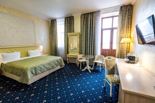文尼察法兰西酒店的酒店客房带一张床、一张桌子和椅子