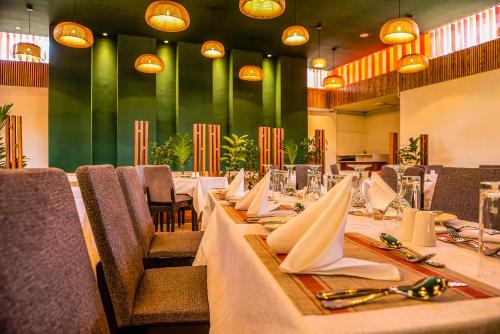 内罗毕Hotel Boulevard Nairobi, City Centre CBD的用餐室配有长桌、椅子和餐巾纸