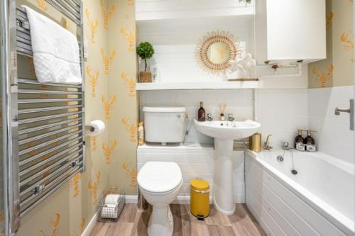 亨斯坦顿Apartment 4, Hunstanton的浴室配有卫生间、盥洗盆和浴缸。