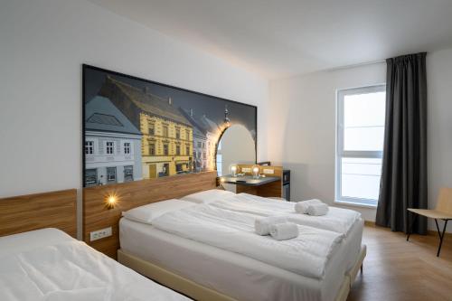 马里博尔B&B Hotel Maribor的一间卧室设有两张床,墙上挂着一幅画