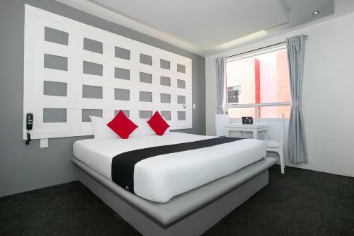 帕丘卡德索托Hotel Euro Confort,Pachuca的白色卧室配有一张带红色枕头的大床