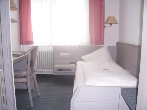 菲尔德施塔特兹莫尔曼酒店的小房间设有床、书桌和窗户