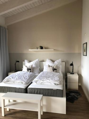 奥斯特若菲尔德Ferienwohnung Mester的卧室设有2张床和白色的墙壁。