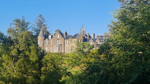 奥本Glencruitten House的一座大建筑,位于一些树中间