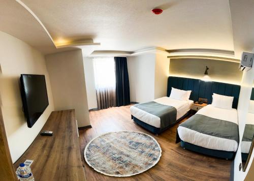 安卡拉Nira Boutique Hotel的酒店客房设有两张床和一台平面电视。