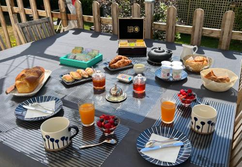 滨海布隆维尔ENTRE TERRE ET MER的一张桌子,上面有早餐食品和饮料