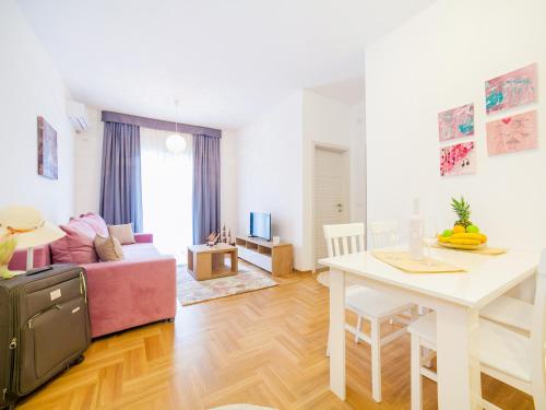 布德瓦Peace 2 Apartments with parking的客厅配有粉红色的沙发和桌子
