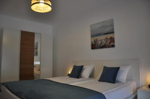 尼普顿Coral ONIX的一间卧室配有两张床、镜子和吊灯。