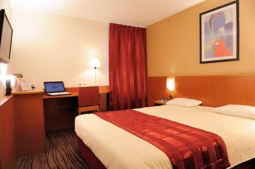 埃夫勒基里亚德厄弗内特维勒酒店的酒店客房配有一张床铺和一张书桌上的笔记本电脑