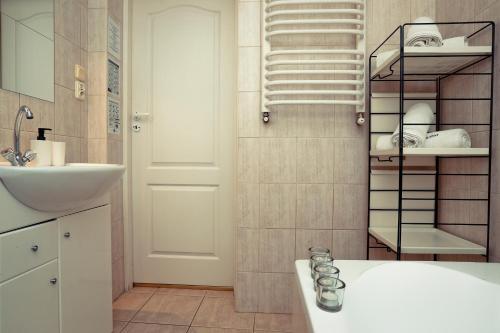 扎科帕内Apartament Giencyno Koncina Zakopane的浴室设有水槽和带毛巾的架子。
